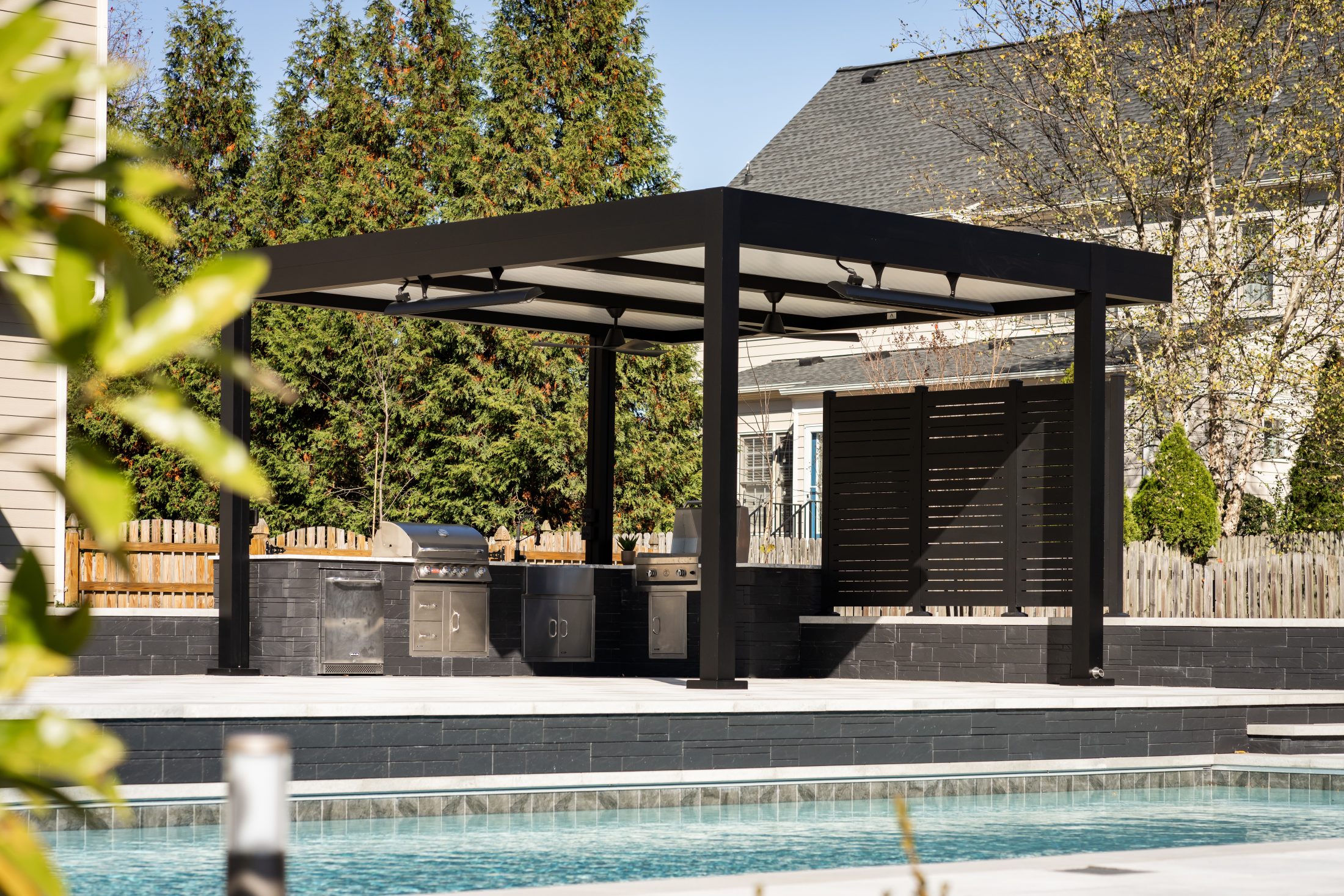 Pergola with integrated fans, heaters, and recessed lighting over outdoor kitchen