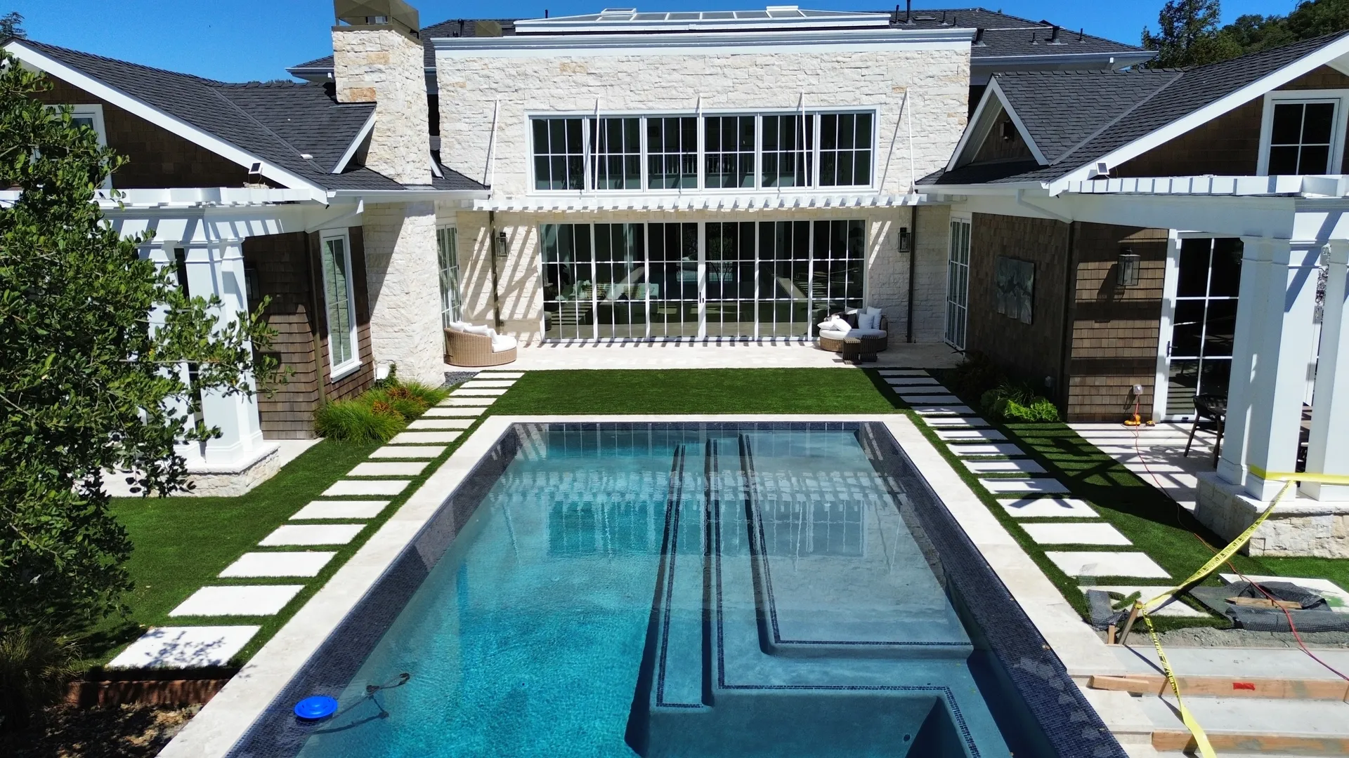 Aerial view of complete landscape design with pool, lawn, hardscape, and mature plantings