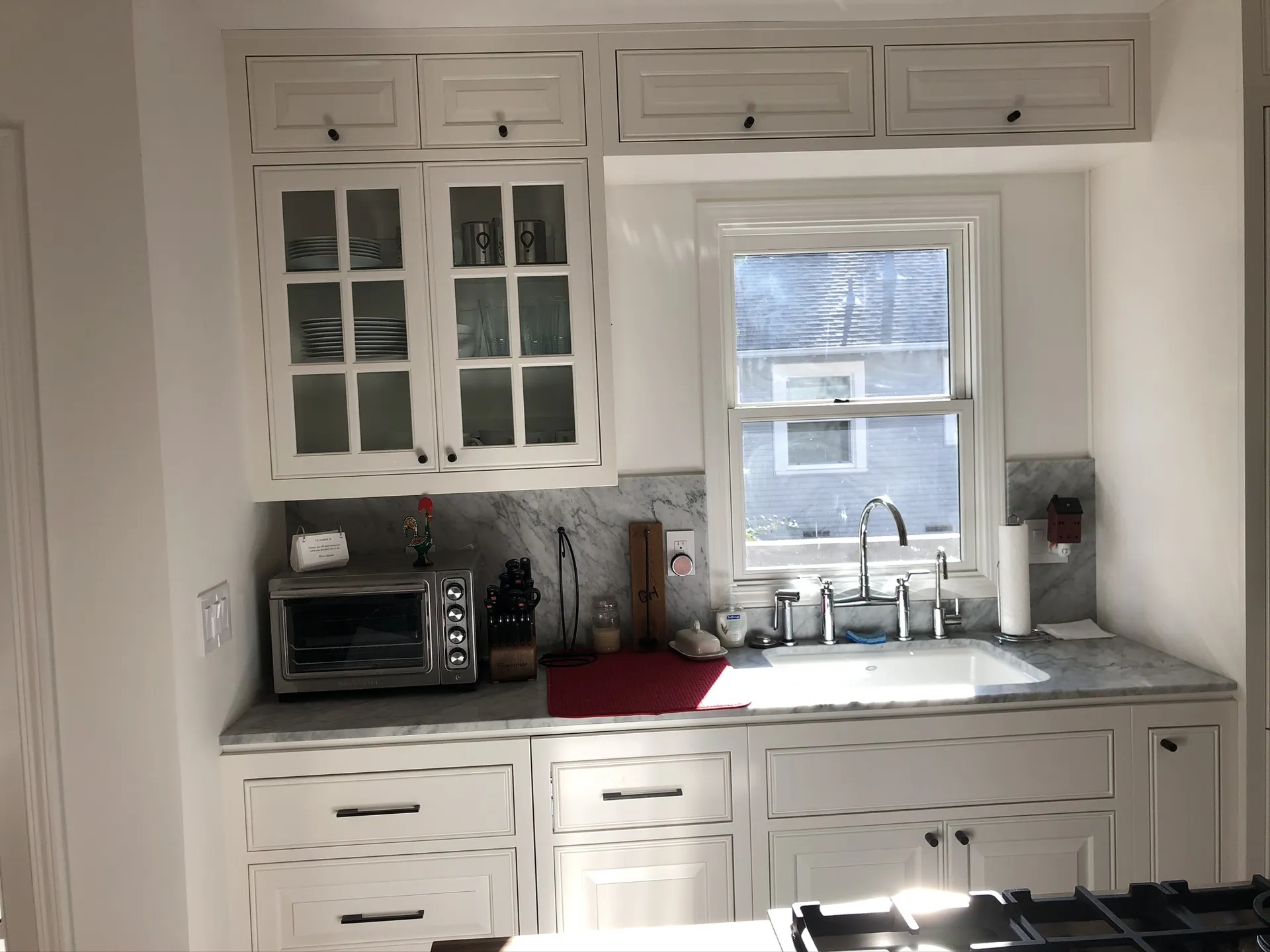 Modern kitchen remodel details — cream cabinets, dark wood island, gas cooktop